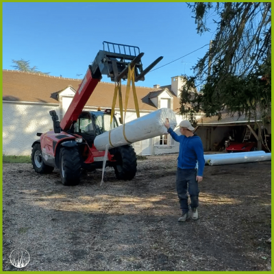 Manitou qui porte un rouleau de gazon artificiel